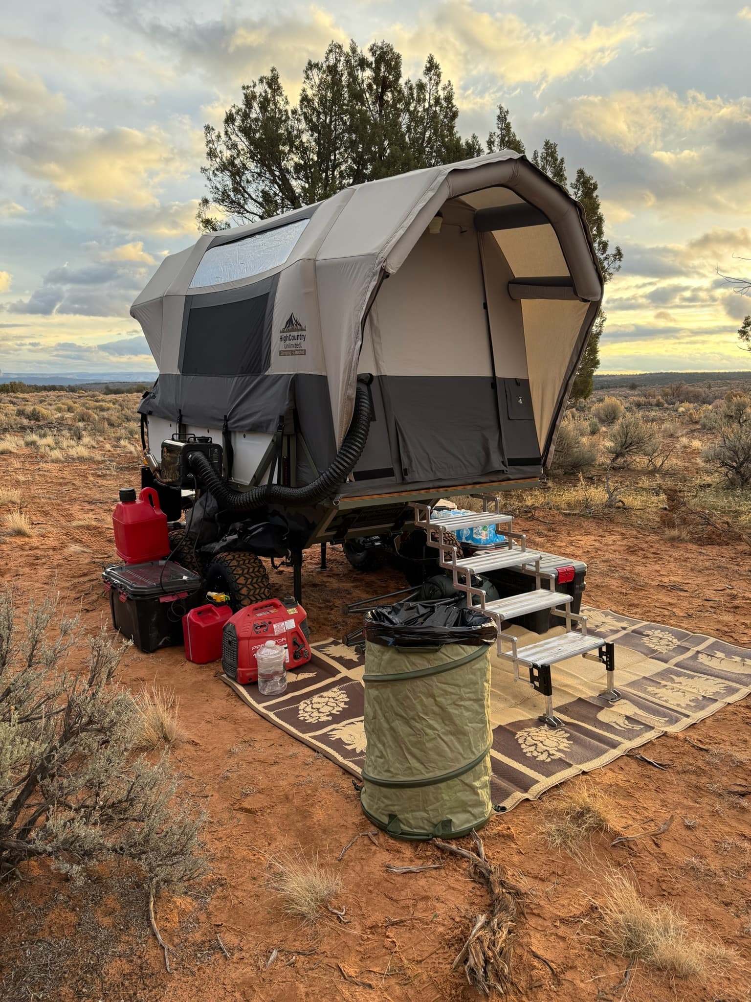 Conestoga Rover set up at a high-desert camp at sunset with airframe tent deployed